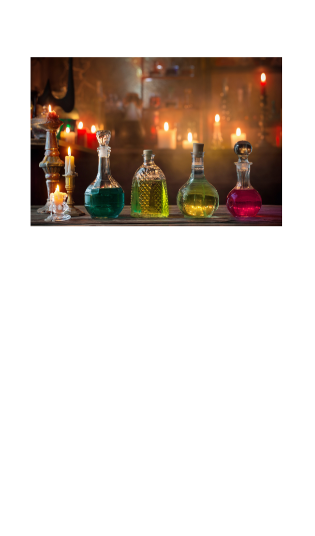 Potions on a table with candles in the background.